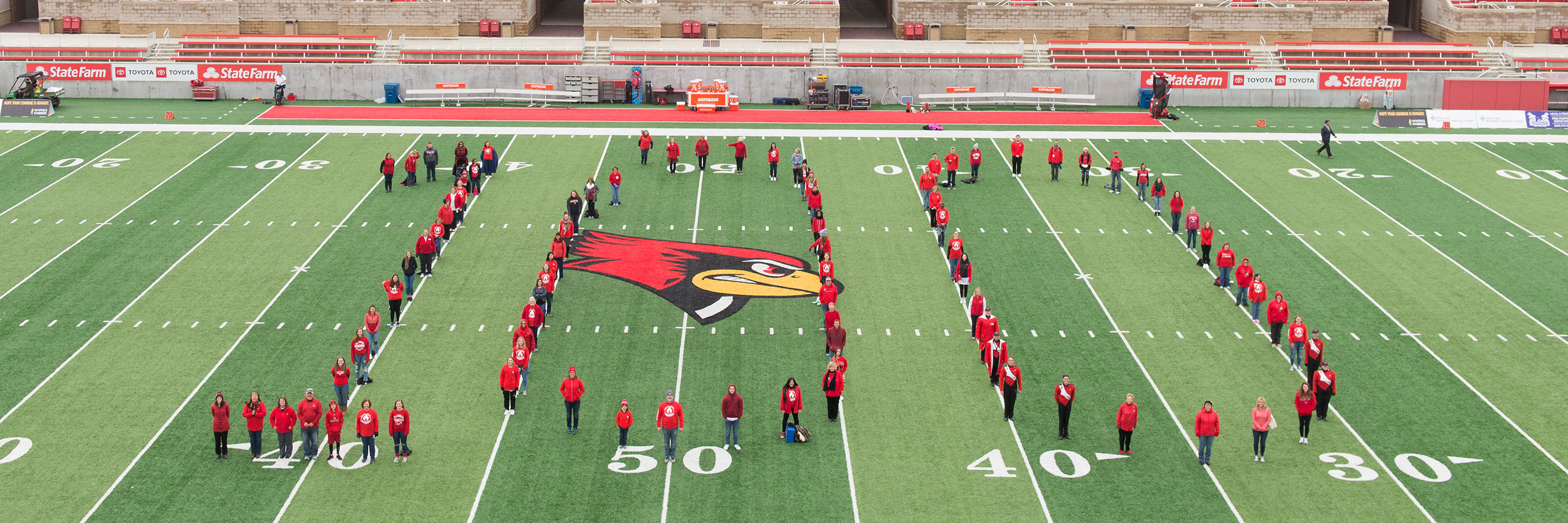 MCN faculty and staff form a number 100 on the football field