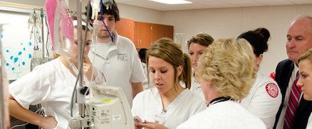 Students looking at a machine in a lab.