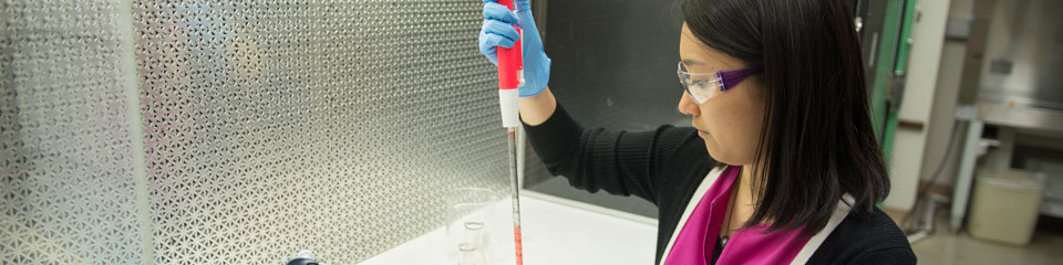 A nurse fills a beaker in a lab.