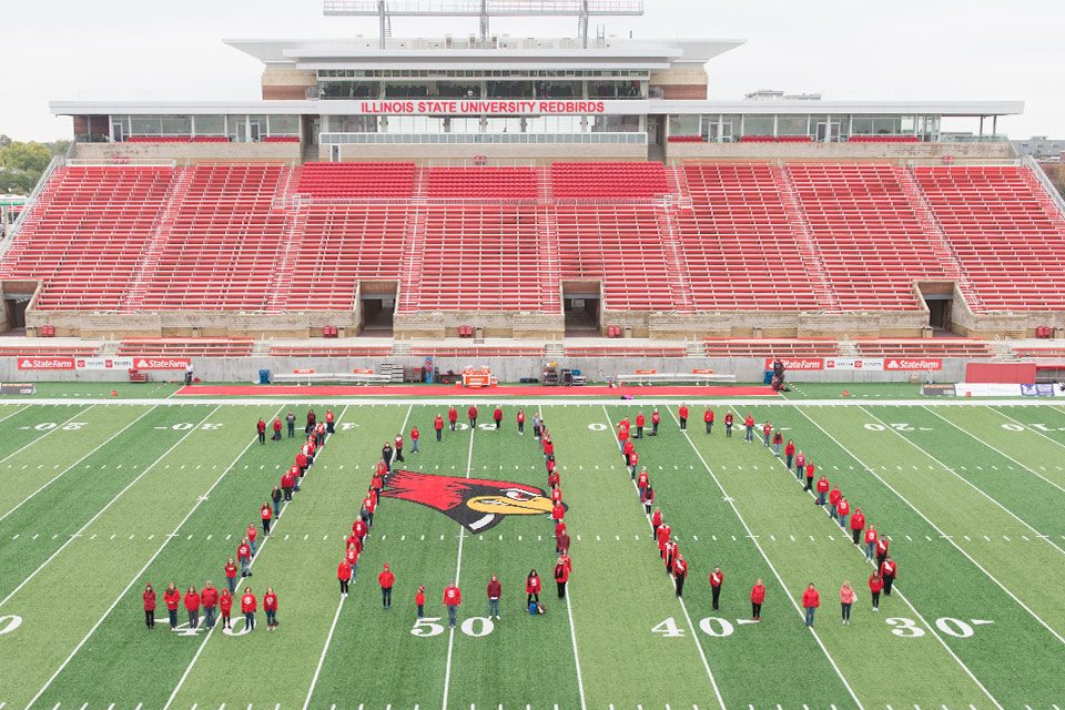 MCN faculty and staff form a number 100 on the football field