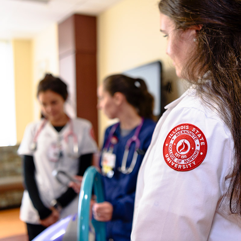 Two students and professor in a nursing lab.