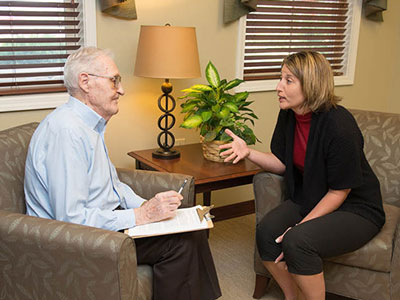 Dr. Michele Shropshire speaks to an elderly man.