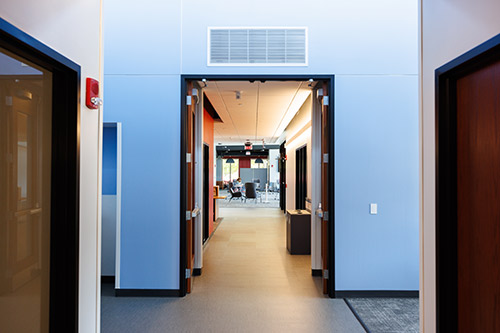 An interior hallway displaying a door and door frame, emphasizing the minimalist aesthetic of the space.