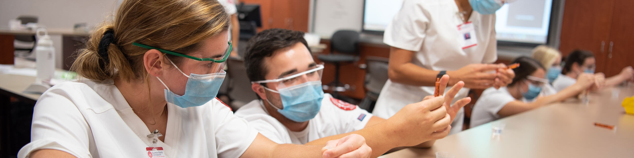 Nursing students work together in class.