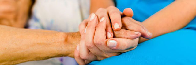 Nurse holding hands with patient.